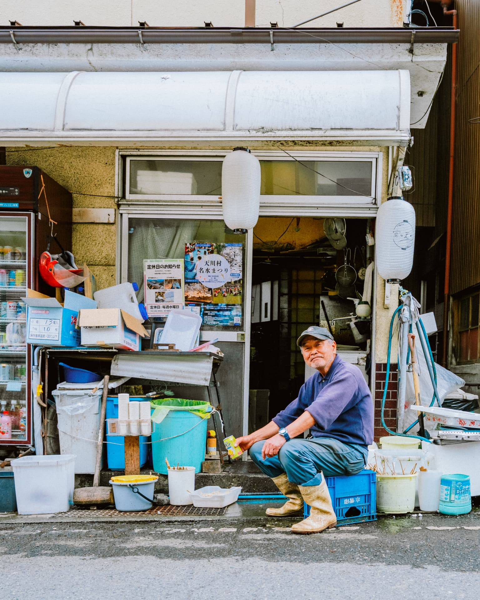 Commerçant japonais assis devant sa boutique de village
