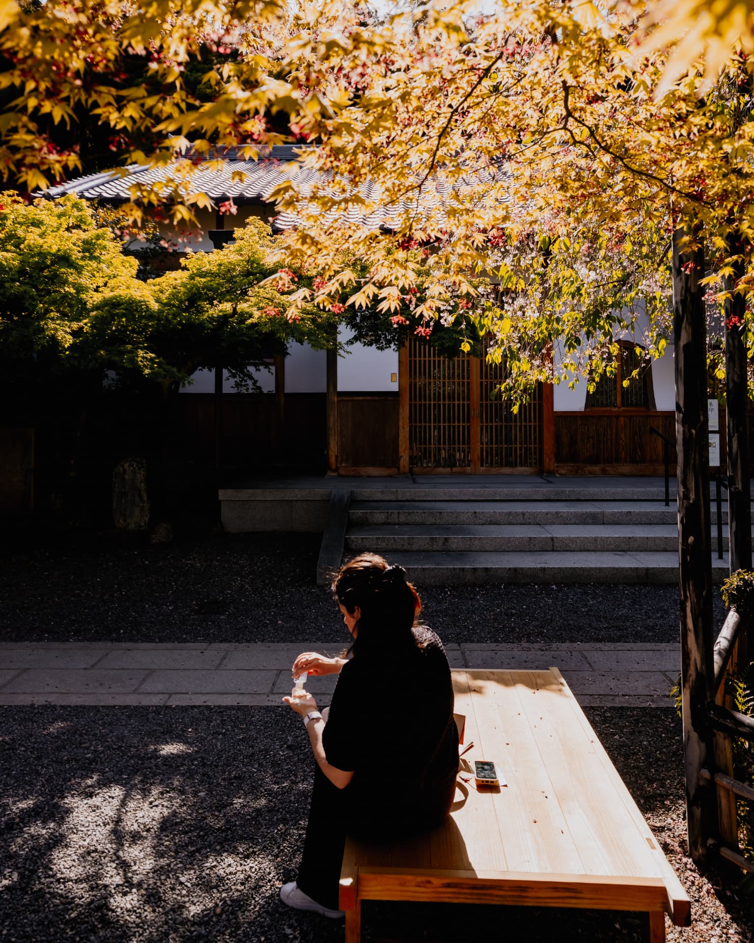 Pause sur un banc de bois dans un jardin de temple aux érables dorés